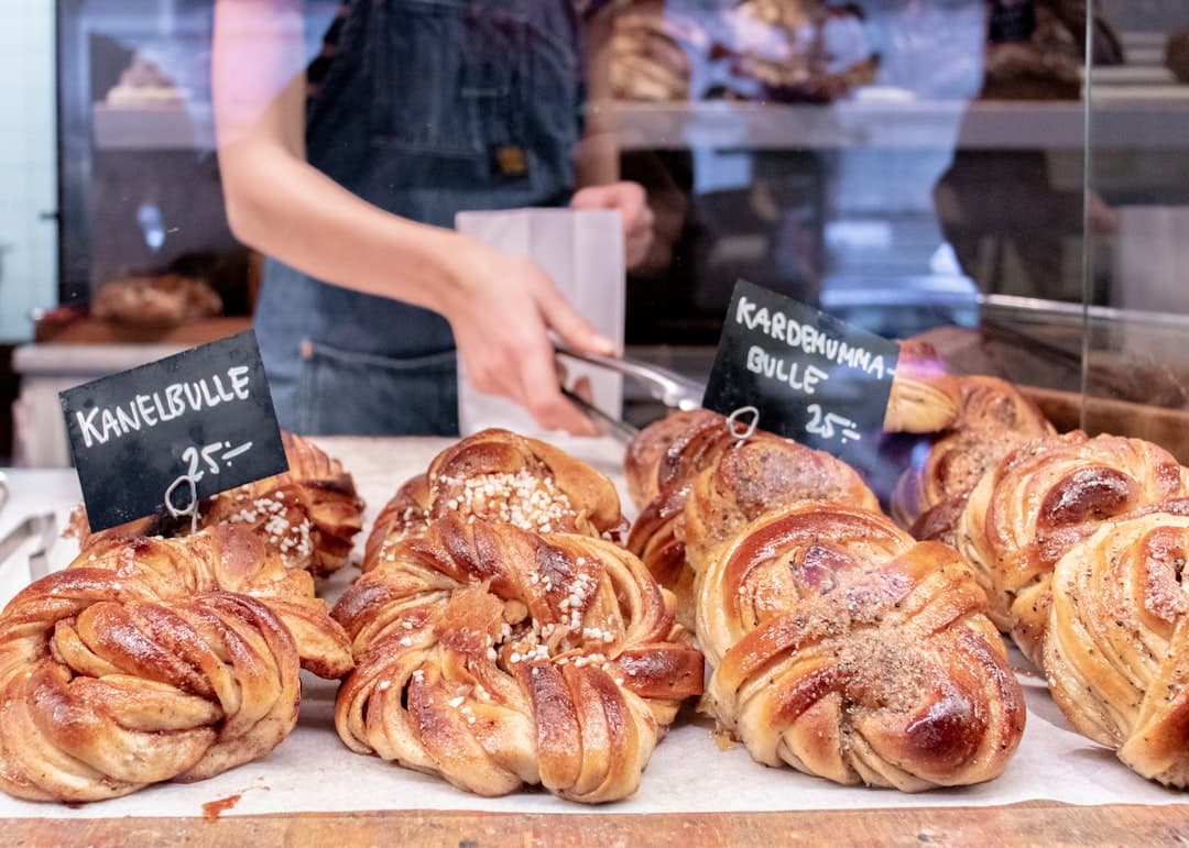 Disk full med kanelbullar och kardemummabullar med handskrivna prisskyltar