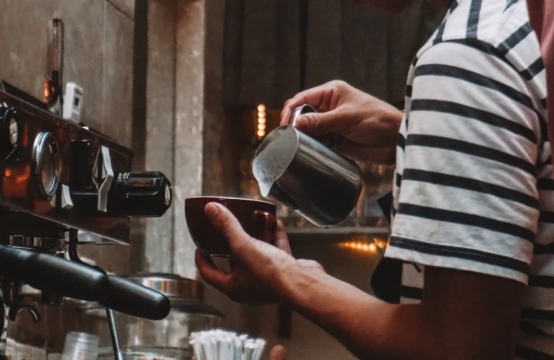 Barista häller mjölk i en espressokopp
